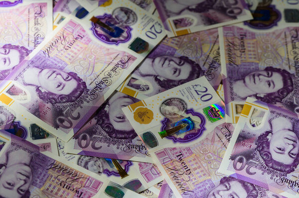 Банкноты по 20 фунтов стерлингов, формирующие финансовый фон, представляющие деньги, финансы, сбережения и экономику Великобритании.