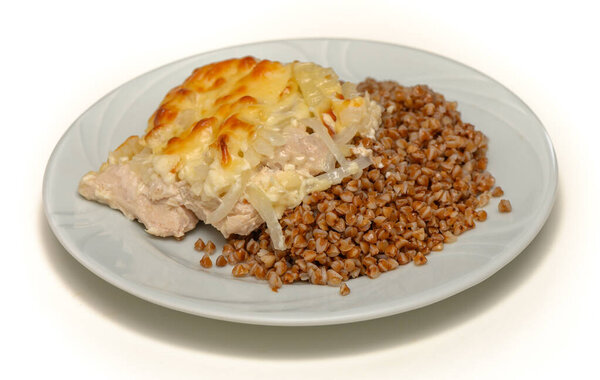 Buckwheat porridge with roasted meat on white background