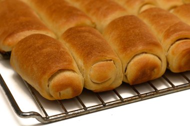 Sıcak ev yapımı Parker House ruloları mutfak masasındaki tel askıda soğuyor..