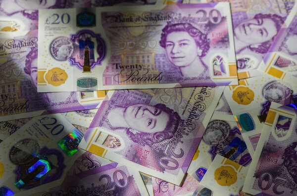 Макро крупным планом из 20 банкнот из Великобритании показывает текстуру и дизайн, формируя финансовый фон, символизирующий богатство, сбережения и экономику.