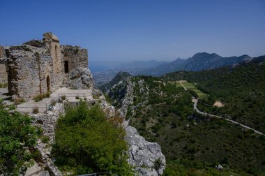 Dağlara ve Kuzey Kıbrıs 'taki Akdeniz' e karşı kurulan St. Hilarion Kalesi 'nin çarpıcı manzarası. Ortaçağ mimarisi ve doğanın mükemmel bir karışımı..