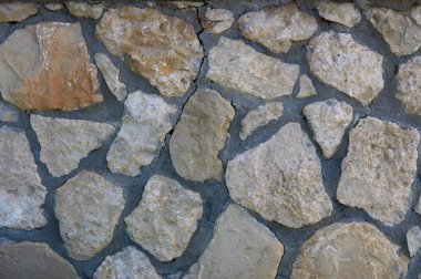 Engebeli taşlar büyüleyici bir duvar oluşturur. Sıcak güneş ışığı altında toprak gölgeleri ve doğal şekilleri harmanlarlar..