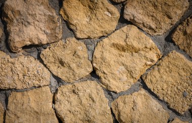 Arka plan olarak kullanılan doğal taş duvar dokusu. Tasarım, mimari, inşaat ve dekoratif projeler için kırsal yüzey deseni mükemmel.