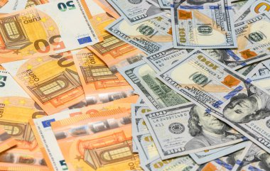 Servet, finans ve uluslararası parayı temsil eden dağınık yüz Amerikan doları ve elli avroluk banknotların yakın plan çekimi.