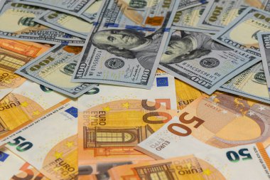 Yakın plan 100 ABD Doları banknotları 50 euro ile karıştırılmış, Forex ticaret, uluslararası ticaret ve küresel finans piyasaları sembolü.
