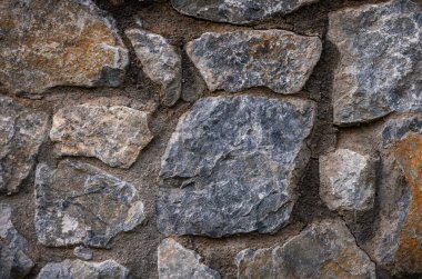 Kıbrıs 'taki doğal taş duvar yüzeyine yakın çekim. Mimarlık, tasarım, posterler ve yaratıcı projeler için nötr dokulu arkaplan.