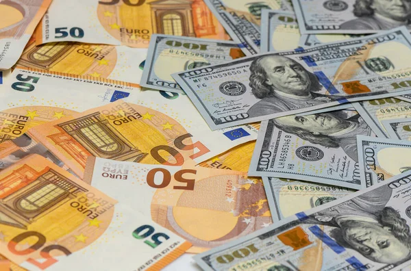 Dağınık 100 Amerikan doları ve 50 avroluk banknotlardan oluşan para arkaplanı, uluslararası ekonomi, tasarruf ve bankacılık finans sembolü.