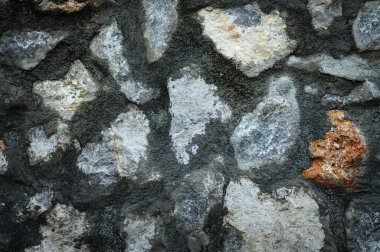 Doğal bir taş duvar dokusunun yakın görüntüsü tasarım, inşaat ve dekorasyon için kırsal bir zemin. Gerçek taş desenli pürüzlü bir yüzey..