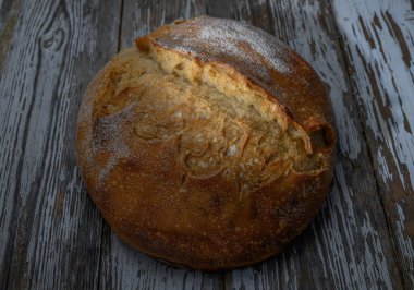Köy ahşap bir masaya taze pişmiş tam tahıllı ekmek. Doğal organik malzemeli ve geleneksel tarifli sağlıklı ev yapımı fırın..