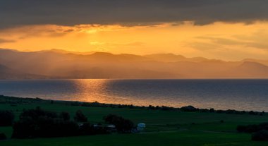 Gün batımında Kıbrıs 'taki Morphou Körfezi manzaralı bir terastan görülüyor. Güzel deniz, kıyı şeridi ve sıcak akşam gökyüzü seyahat ve turizm kavramları için mükemmel..