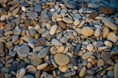 Kıbrıs kıyılarındaki pürüzsüz deniz taşları yakından çekildi. Tasarım, doğa, seyahat ve rahatlama kavramları için doğal doku arka planı mükemmeldir..