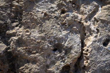 Yakından çekilen engebeli dağ taşı yüzeyinin detaylı görüntüsü. Tasarım, doğa ve açık hava projeleri için doğal kaya dokusu ideal..