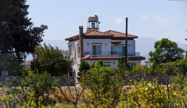 KKKTC 'nin kiremitli çatıları ve Akdeniz atmosferi olan bir köyünde geleneksel taş evleri cezbediyor. Resimli kırsal mimari ve otantik ada yaşam tarzı.