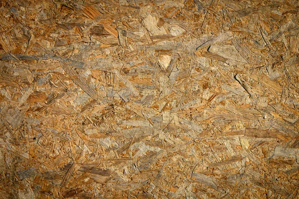 Arka plan için OSB ahşap tahta dokusu yakın plan. OSB 'nin yüksek kalite makro karesi ahşap iplikleri ve dokuları gösteriyor. Arkaplan, inşaat ve tasarım stoku resimleri için mükemmel.