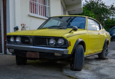 Lefke, Kıbrıs 05.30.2025 Kuzey Kıbrıs, Lefke 'de güneşli bir sokakta klasik sarı Mitsubishi Galant Lambda. 1970 'lerin sonlarında korunmuş nadir bir coupe..