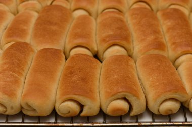 Taze pişmiş Parker Evi, serinlemek için tel askıda duran altın hamurlu rulo..