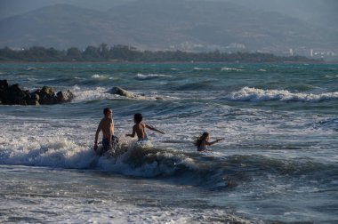 Kıbrıs sahillerindeki Akdeniz 'de yüzen ve oynayan çocuklar. Mükemmel yaz tatili, turizm ve aile tatili konsepti..