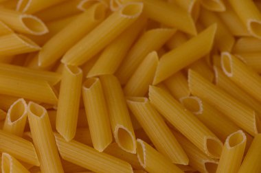 Makro desenli kuru meze makarna. Klasik İtalyan yemek arkaplanı. Sıcak sarı tonlarda..