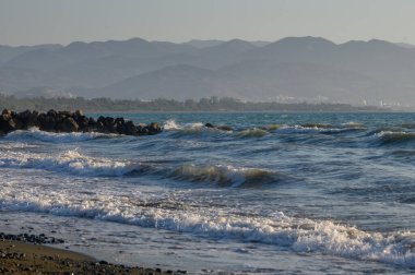 Akdeniz 'in berrak dalgaları yaz güneşinin altında Kıbrıs' ın kumlu kıyılarını yıkayarak, gevşemeyi ve tatil havasını simgeliyor.