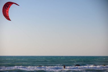 Uçurtmacı, çarpıcı bir dağ zeminiyle ve berrak yaz atmosferiyle Kıbrıs 'ta Akdeniz' in dalgalarında yüzüyor