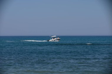 Kıbrıs Rum Kesimi yakınlarındaki Akdeniz sularında bir motorlu botla gezintiye çıkan insanların yakın çekimleri, boş zamanları ve seyahat deneyimlerini vurguluyor