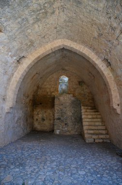 Saint Hilarion Kalesi 'nde dar bir pencereden içeri giren yumuşak ışık ortaçağ taş duvarlarına gölge düşürüyor..
