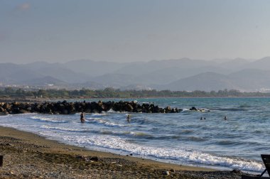 Kıbrıs 'ın ılık Akdeniz sularında yüzen ve oynayan insan grupları, parlak güneşin altında yaz tatillerinin tadını çıkarıyorlar..