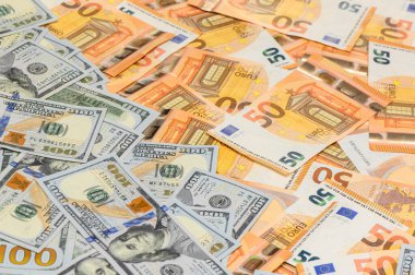 Yüz dolarlık banknotlar ve elli avroluk banknotlarla kaplı bir masanın yakın plan çekimi, ekonomi, ticaret ve yatırım kavramları için mali bir geçmiş oluşturur.