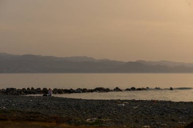 Kıbrıs kıyılarındaki Akdeniz 'in sakin suları üzerinde güzel bir günbatımı barışçıl ve sıcak bir atmosfer yaratıyor..