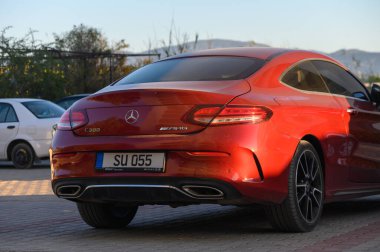 Kırmızı Mercedes SLK 250 üstü açılır araba bir ev yakınına park edilmiş. Lüks spor araç