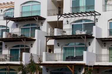 Kıbrıs 'ta minimalist Akdeniz mimarisinin yer aldığı bir grup beyaz villa. Parlak gün ışığı ve huzurlu ortam.