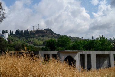 Tamamlanmamış bir konut, Kuzey Kıbrıs 'ta görülen sembol olan ikonik Atatürk siluetinin yer aldığı dağlık bir arkaplan karşısında duruyor..