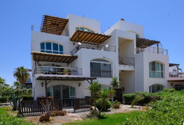 Kıbrıs 'ta denize yakın huzurlu yerleşim bölgesinde parlak beyaz villalar.