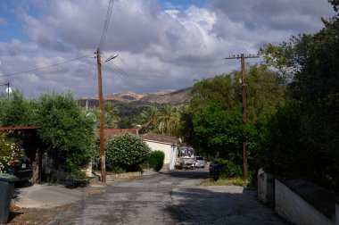 Arka planda dağların manzaralı manzaralı bir Kıbrıs köyünde geleneksel cadde.