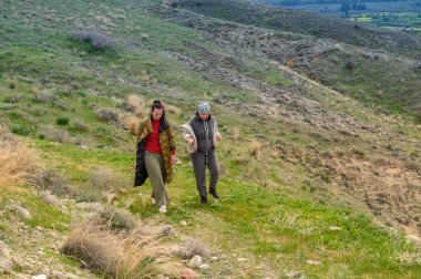 İki arkadaş çimenli bir yamaçta yürürler, temiz havanın ve doğanın güzelliğinin tadını çıkarırlar. Manzara canlı ve yeşil ve yumuşak yamaçlarla dolu..