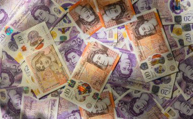 İngiliz sterlin notaları ahşap bir masanın üzerine sergilenmiş, parlak bir sahnede zenginlik sergiliyor.