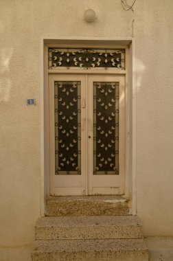 Kıbrıs 'ta geleneksel bir evde kırsal dokusu olan eskimiş beyaz ahşap kapı, Akdeniz cazibesini çağrıştırıyor.