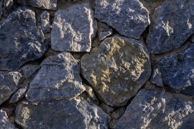 Doğal taştan duvar dokusunun yakın çekimi. Tasarım, mimari, inşaat, Akdeniz tarzı ve dekoratif yüzey için kırsal arkaplan kavramı