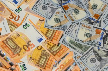 100 dolarlık banknotlar ve 50 avroluk banknotlar bir masanın üzerine serpiştirildi..