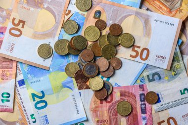 Ekonomi, tasarruf ve gelir sembolü olarak mali geçmiş olarak düzenlenmiş avro banknotları ve sikkeler.