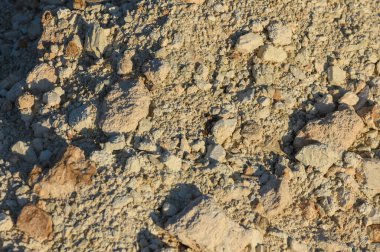 Toprak, toprak, kaya ve çakıl taşlarından oluşan bir duvar halısını gün ışığına çıkarır..