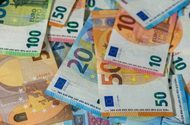 Avro banknotlarının kapatılması ahşap masaya yayılmış, mezhepler, doku ve Avrupa finans kavramı vurgulanmış.