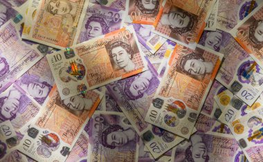 Arka plan olarak UK 10 ve 20 Sterling banknotlarının ayrıntılı kapatılması, finans ve ekonomi için doku ve mezheplerin vurgulanması.