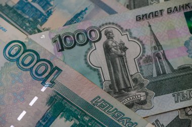 Bir masaya yerleştirilmiş Rus 1000 rublelik banknotlar, finans, bankacılık ve iş görselleri için derinlik ve dinamik para arkaplanı oluşturur.