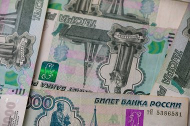 Bir masanın üzerine dağılmış Rus 1000 rublelik banknotlar, finans, yatırım ve iş görselleri için zengin bir fon oluşturur.