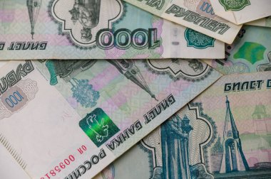 Bir masaya dağılmış Rus 1000 rublelik banknotlar finans, zenginlik ve para kavramları için dokulu bir arka plan oluşturur..