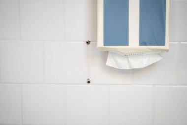 Beyaz kiremitli bir duvardaki doku dağıtıcısına yakın plan.