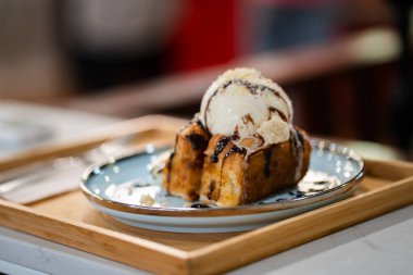 Tatlı tatlı dondurma, çikolata sosu ve muz dilimleri.