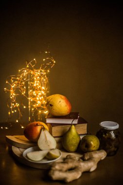 Kiev / Ukrayna - 6 Haziran 2018: fotoğraf üzerinde taze armut, bir kavanoz reçel ve zencefil kökü kitap ve ışıklar arka planı vardır.