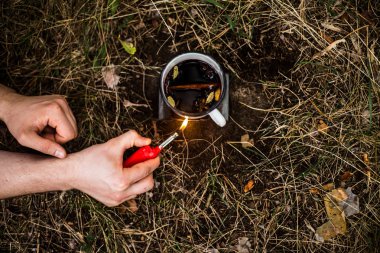 Bir turist sobayı üzerinde doğada mulled şarap pişirme